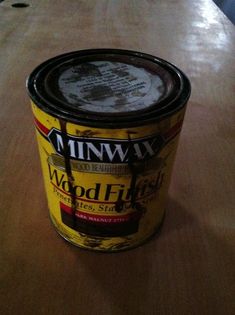 a can of wood finish sitting on top of a wooden table