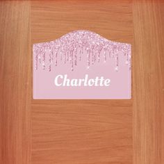 a wooden door with a name plate on it and pink glitters in the background