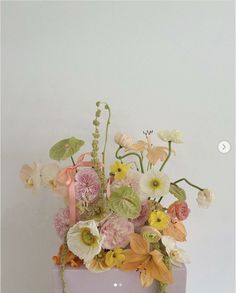 a vase filled with lots of flowers on top of a table