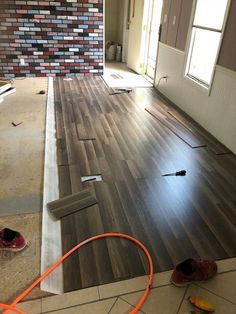 an empty room with wood flooring being laid on the ground in preparation for painting