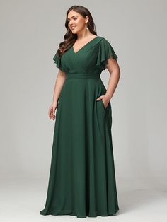 a woman in a green dress posing for the camera with her hands on her hips