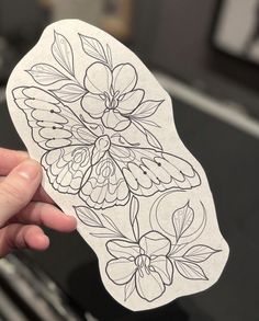 a person holding up a sticker with flowers on it