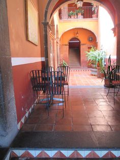 several chairs are lined up in an arched room with tile flooring and red walls