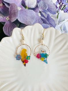 These charming handmade earrings feature  two different kinds of adorable parrots adorned with glistening fresh water pearls delicately dangled as drop earrings. Handmade of shrink plastic, these delicate bird pieces could be a perfect gift for bird enthusiasts and those who appreciate unique, artisanal jewelry.  These earrings capture the whimsical beauty of nature and make a delightful addition to any jewelry collection. Contact me if you want two same style of birds Multicolor Bird Design Earrings As A Gift, Multicolor Bird Design Earrings For Gift, Multicolor Bird Design Earrings Gift, Gift Multicolor Bird Design Earrings, Dangle Earrings With Bird Design For Gift, Whimsical Bird Design Jewelry For Gifts, Whimsical Bird Design Jewelry For Gift, Whimsical Bird Design Earrings For Gift, Shrink Plastic Jewelry