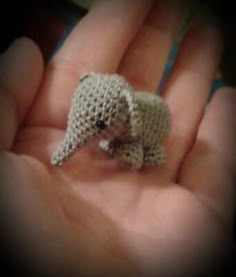 someone holding a tiny crocheted elephant in their hand