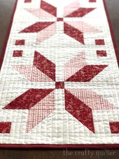 a red and white quilted table runner