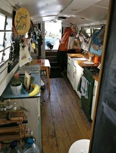 the inside of an rv with lots of clutter on the counter and wood flooring