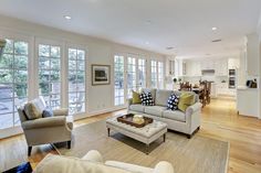 a living room filled with furniture and lots of windows