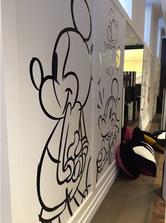 the wall is decorated with black and white cartoon characters on it's walls, along with other decorations