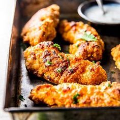 some chicken wings are on a tray with dipping sauce