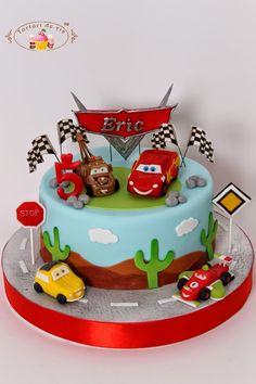 a birthday cake decorated with cars and flags