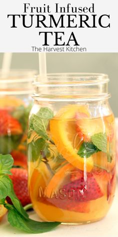 fruit infused tumericic tea in a jar with strawberries and oranges