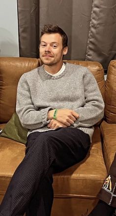 a man sitting on top of a brown couch