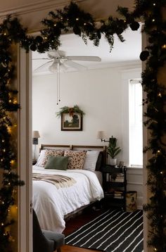 a bedroom decorated for christmas with garland and lights