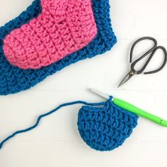 the crocheted purse is next to scissors and yarn