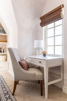 a white desk and chair in a room with a rug on the floor next to it