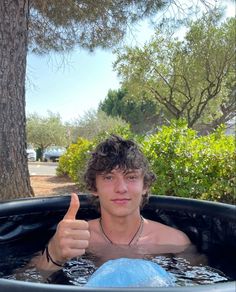 a young man in a large pool giving the thumbs up sign