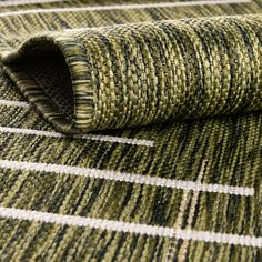 a close up view of a green and white rug with vertical lines on it's surface