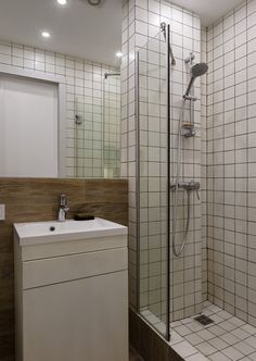 a bathroom with a sink, shower and tiled walls on the wall next to it