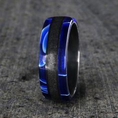 Like the expanse and depth of space, this blue acrylic and stardust ring highlight the glimmer of stars and bursts of color. This stardust ring is made with care and precision to ensure comfortable all-day wear and durability for the everyday activities of life. 7mm wide stardust and acrylic ring (shown) Certified Gibeon meteorite stardust Blue acrylic edges Black zirconium sleeve Rounded profile Inside Comfort Fit Design Handmade in the USA Meteorite Rings, Meteorite Wedding Band, Gibeon Meteorite, Meteorite Jewelry, Acrylic Ring, Meteorite Ring, The Solar System, Wide Rings, Blue Rings