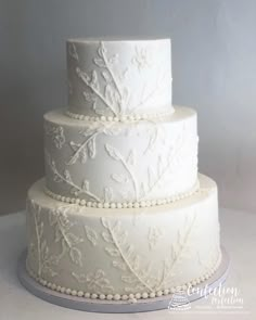 a three tiered wedding cake with white frosting