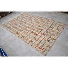 a beige rug with multicolored squares on the floor in a living room area