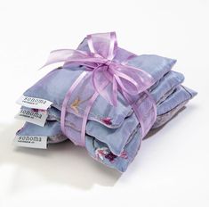 three pieces of cloth wrapped in purple ribbon and tied to each other with tags on them