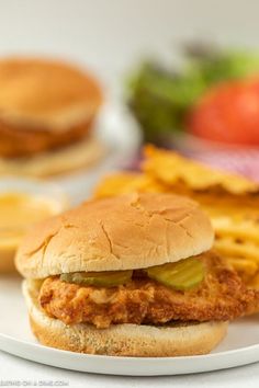 a chicken sandwich on a plate with french fries