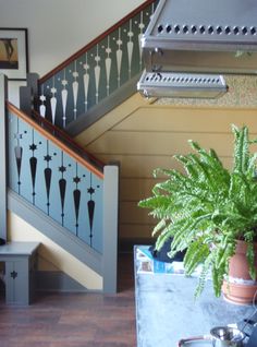 there is a potted plant sitting on the table in front of the stair case