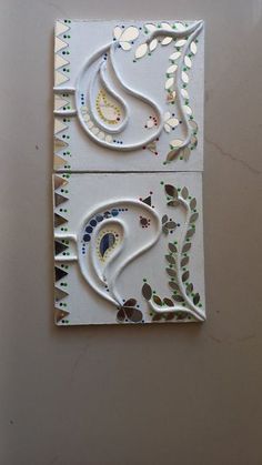 two pieces of art made out of white and green paper with designs on the sides