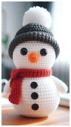 a crocheted snowman wearing a hat and scarf