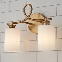 two light bathroom fixture with white glass shades on the bottom and gold metal fixtures above it