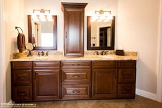 a bathroom with double sinks and two mirrors