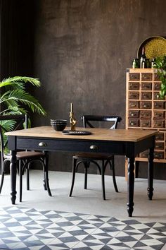 a black table with two chairs and a potted plant