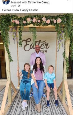 a man and two children are sitting on a swing in front of a sign that says easter