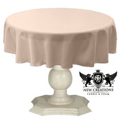 a round table with a white base and a light pink cloth on it's top