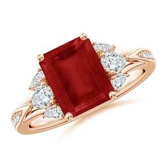 an engagement ring with a red stone surrounded by white diamond accents on the shoulders and sides