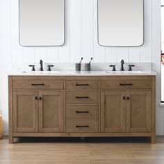 a bathroom with two sinks and mirrors on the wall