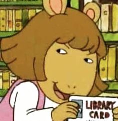 a girl holding up a library card in front of bookshelves