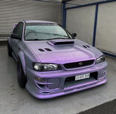 a purple car parked in front of a garage