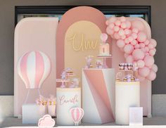 a table with balloons, cake and other items on it in front of a wall