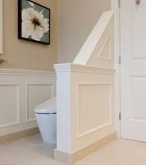 a white toilet sitting in a bathroom next to a doorway with a framed flower on the wall