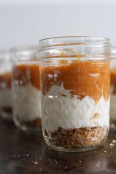 small jars filled with desserts sitting on top of a wooden table next to each other