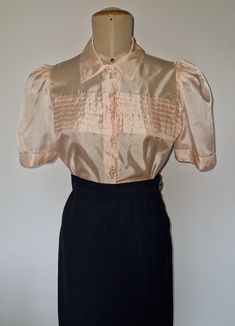 Vintage 1940s hollywood sheer pink art deco puff sleeves and pleated decoration  blouse S Lovely sheer fabric, pointed neckline and lucite buttons perfect for 40s party, everyday vintage look. Measurement lying flat: 36cm from shoulder seam to shoulder seam 50 cm pit to pit 44,5 cm waist 51,5 cm from shoulder seam to hem 29cm sleeves from shoulder  It is in good condition according with the age,  Little different button on bottom and hand stitching made after production.  Transparent fabric with small invisible spots. Pictures sometimes alterate the colors it's inevitable Any question, please ask. Vintage Gold Fitted Blouse, Vintage Long Sleeve Pink Blouse, Vintage Pink Collared Shirt, Vintage Pink Blouse With Button Closure, Vintage Pink Button-up Blouse, Pink Art Deco, Pink Art, Look Vintage, Sheer Fabrics