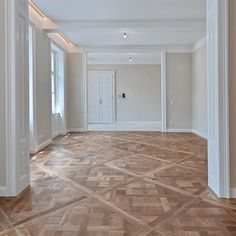 an empty room with wood flooring and white trim on the walls is seen in this image