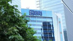 a tall building with the word riesn on it's side in front of trees