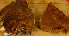 two pieces of meat sitting on top of a cutting board