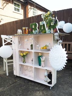 an outdoor bar is decorated with flowers, lemons and greenery for a party