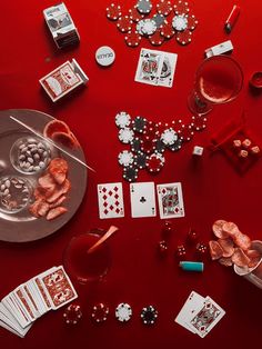 a red table topped with lots of cards and dice