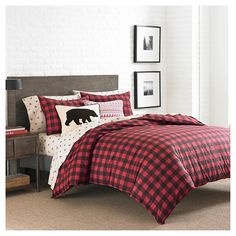 a bed with red and black plaid comforter set